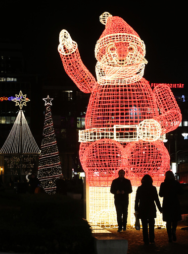 People walk past Christmas illuminations in Berlin