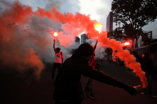 Workers hold fireworks during a protest marking May Day in Surabaya