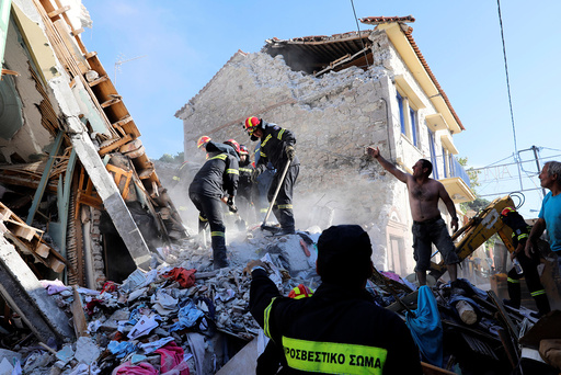 Rescue team members search for victims at a collapsed building in the village of Vrissa on the Greek island of Lesbos