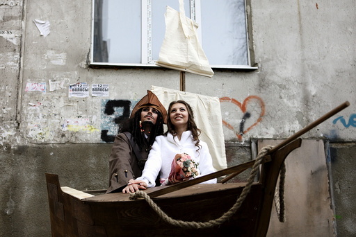 Krasitsky from Russia dressed as movie character Captain Jack Sparrow and his bride Anastasiya pose with a sailing ship decoration during their wedding ceremony in Stavropol