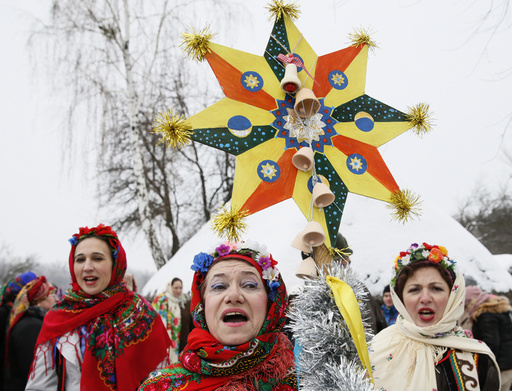 Women dressed in traditional costumes sing Christmas carols as they gather to celebrate the Orthodox Christmas at a compound of the National Architecture museum in Kiev