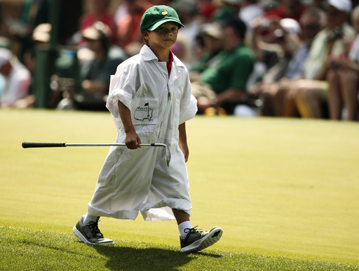 U.S. golfer Tiger Woods' son Charlie carries one of his father's clubs along the fourth hole during the par 3 event held ahead of the 2015 Masters at Augusta National Golf Course in Augusta