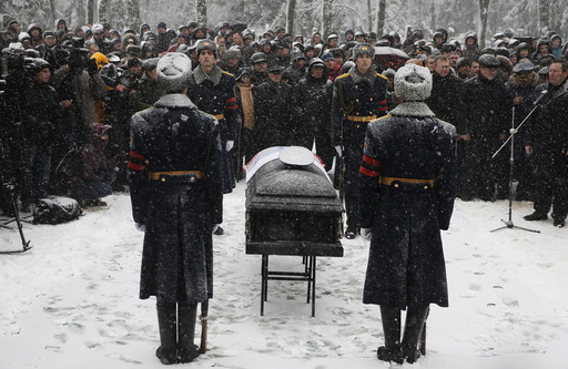 Members of an honor guard stand at attention next to the coffin holding the body of Oleg Peshkov, a Russian pilot of the downed SU-24 jet, during a funeral ceremony at a cemetary in Lipetsk