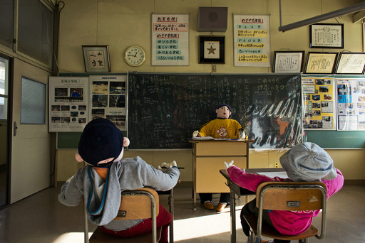Scarecrows representing pupils and a teacher sit in a classroom in a closed down school in the village of Nagoro