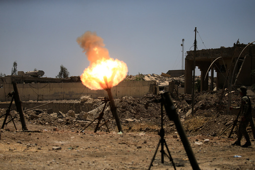 A member of the Iraqi rapid response forces fire mortar shells towards Islamic State militants during a battle with Islamic State militants in al-Zanjili neighborhood