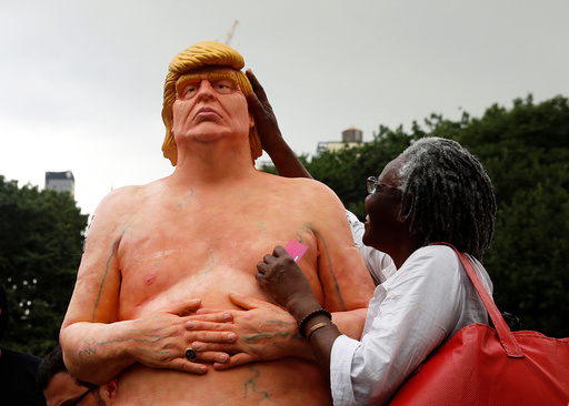 A woman touches a naked statue of U.S. Republican presidential nominee Donald Trump that was left in Union Square Park in New York City