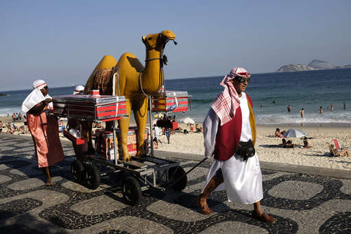Street vendors in traditional Arabic outfits walk at Ipanema beach in Rio de Janeiro
