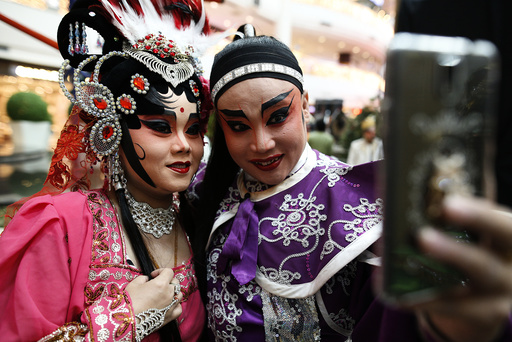 Members of a Chinese opera take a selfie before a performance at a shopping mall ahead of the Chinese Lunar New Year celebrations in Bangkok