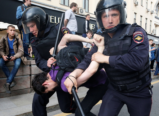 Riot police detain a man during an anti-corruption protest in central Moscow