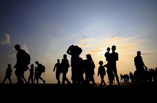 Syrian refugees from Kobani walk at the port of Kos following a rescue opperation off the Greek island of Kos