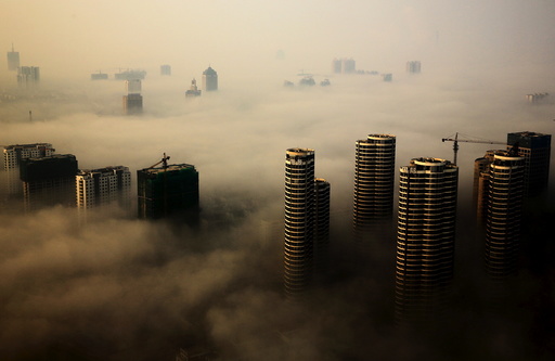 Buildings in construction are seen among mist during a hazy day in Rizhao