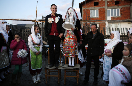 Bulgarian Muslims Azim and his bride Fikrie pose in front of their house during their wedding ceremony in Ribnovo