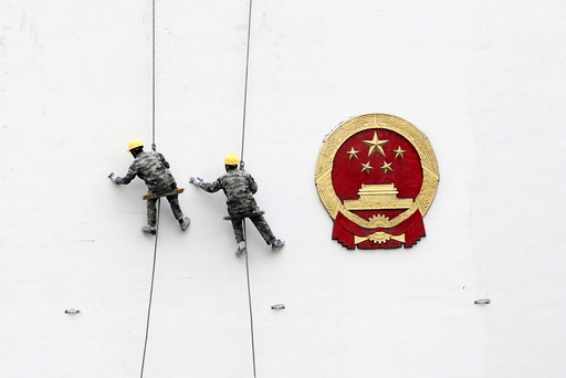 File picture of workers painting a wall of a government building in Hangzhou
