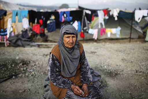 A woman sits at a makeshift camp for migrants and refugees at the Greek-Macedonian border near the village of Idomeni
