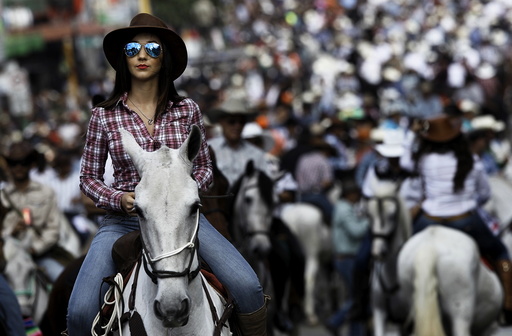 A woman takes part in a traditional horse parade through the streets of San Jose