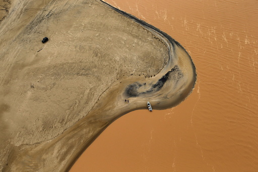 A boat is seen on the mouth of Rio Doce (Doce River), which was flooded with mud after a dam owned by Vale SA and BHP Billiton Ltd burst, as the river joins the sea on the coast of Espirito Santo in Regencia Village