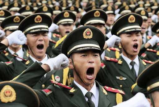 Paramilitary policemen and members of a gun salute team shout slogans at an oath-taking ceremony for the upcoming military parade to mark the 70th anniversary of the end of the World War Two, at a military base in Beijing