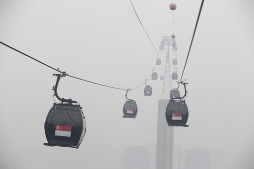 Cable cars moving towards the island resort of Sentosa are shrouded by haze in Singapore
