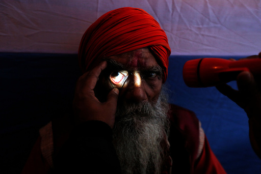 A Sadhu or a Hindu holy man undergoes an eye examination at a free eye-care camp organised by social workers at a makeshift shelter, before heading for an annual trip to Sagar Island for the one-day festival of 