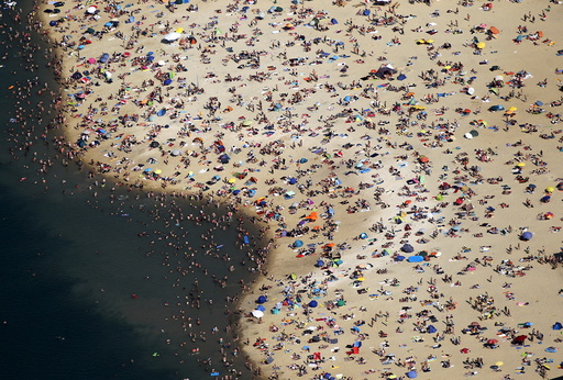 An aerial view shows people at a beach on the shores of the Silbersee lake on a hot summer day in Haltern