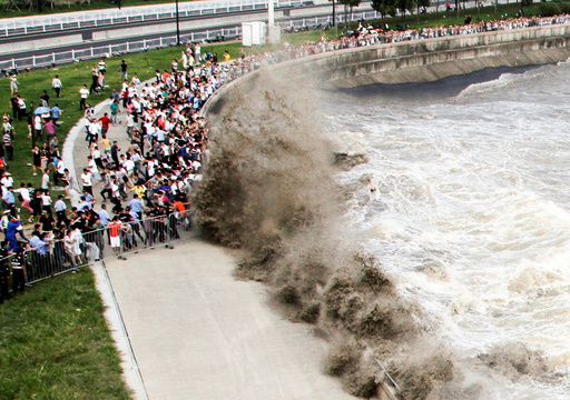 People run away from waves as they watch tidal bore in Hangzhou