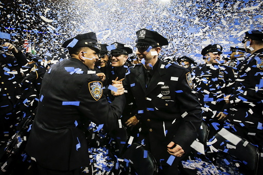 Newly inducted New York Police hug as they take part in a graduation ceremony at Madison Square Garden in the Manhattan borough of New York