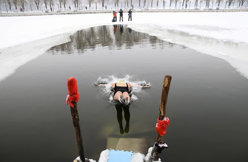 A woman dives into a partially frozen lake at a park in Shenyang