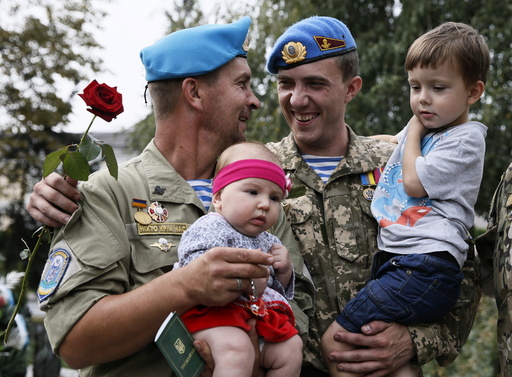 Ukrainian paratroopers, who returned from the frontline in Eastern regions, hold their children during a welcoming ceremony in Kiev