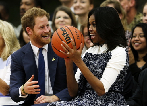 Britain's Prince Harry laughs as U.S. first lady Michelle Obama catches a basketball during a game played by wounded warriors at Fort Belvoir, Virginia