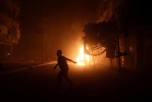 A man runs near a burning car after an airstrike in the rebel held Douma neighbourhood of Damascus