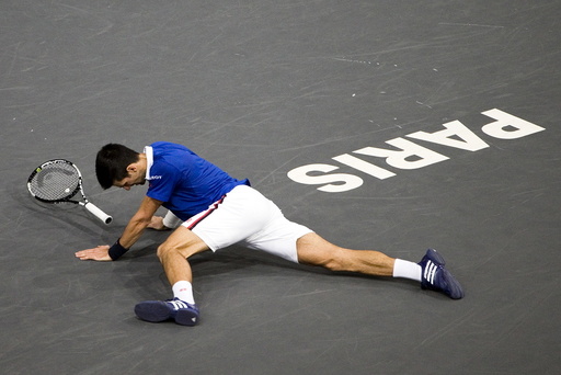Novak Djokovic of Serbia falls as he faces Tomas Berdych of the Czech Republic in their men's singles quarter-final tennis match at the Paris Masters tennis tournament at the Bercy sports hall in Paris