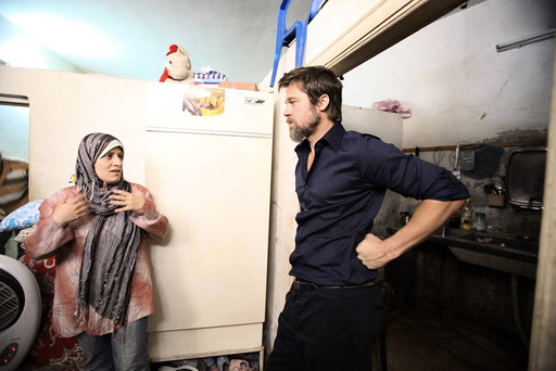 Hollywood actor Pitt, partner of UNHCR Goodwill Ambassador Jolie, listens to an Iraqi refugee living in Jaramana