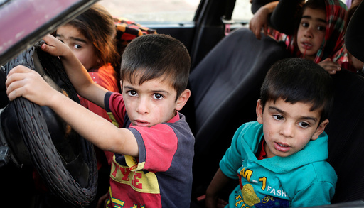 Internally displaced children sit in a car near Hassan Sham, east of Mosul