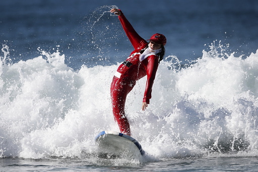 A competitor surfs dressed as Santa Claus during the ZJ Boarding House Haunted Heats Halloween Surf Contest in Santa Monica