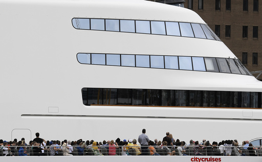 Passengers on a river cruise boat pass superyacht 