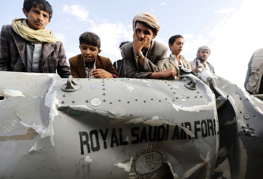 People stand by part of a Saudi fighter jet found in Bani Harith district north of Yemen's capital Sanaa
