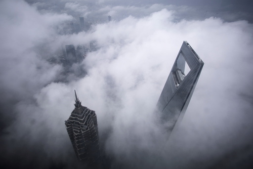 Skyscrapers Shanghai World Financial Center and Jin Mao Tower are seen during heavy rain at the financial district of Pudong in Shanghai