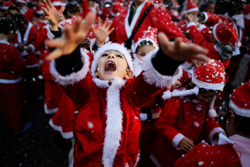 Children dressed as Santa Claus participe in a parade held to collect food for the needy, in Lisbon