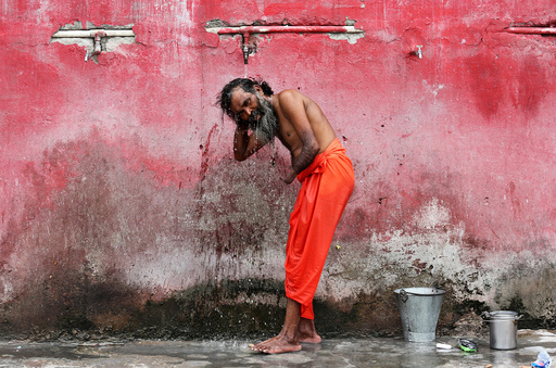 A Sadhu or a Hindu holy man bathes before registering for the annual pilgrimage to the Amarnath cave shrine, at a base camp in Jammu