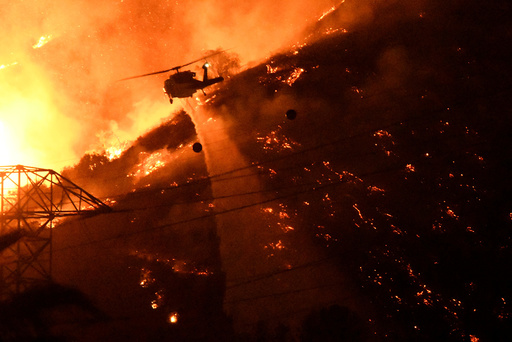 A Los Angeles County fire helicopter makes a night drop while battling the so-called Fish Fire above Azusa, California