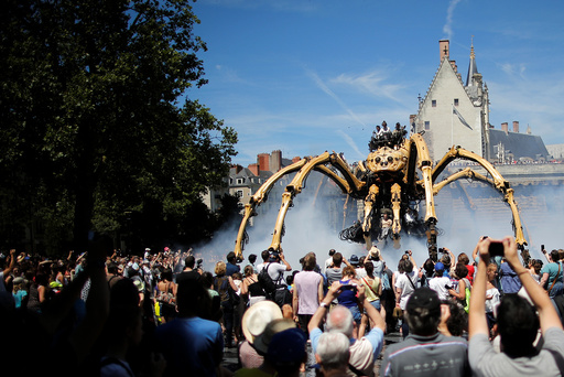 People look at the giant mechanical spider Kumo Ni created by La Machine production company during its presentation in Nantes