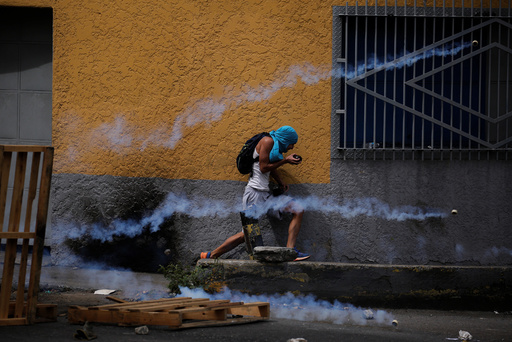 A demonstrator runs away from tear gas during a rally called by health care workers and opposition activists against Venezuela's President Nicolas Maduro in Caracas
