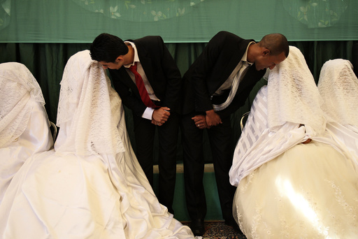 Brides speak to their grooms during a mass wedding ceremony in Amman