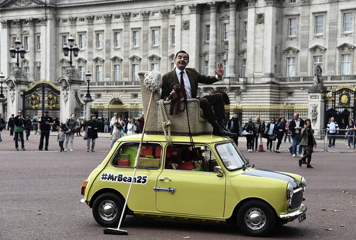 British comedian Atkinson, in character as 'Mr Bean', poses on a Mini car, during a publicity event near Buckingham Palace in central London