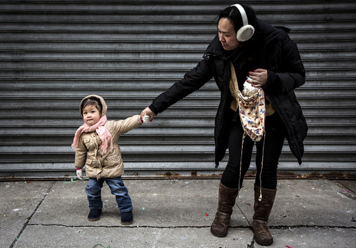 A child pulls her mother away from Chinese Lunar New Year celebrations in New York