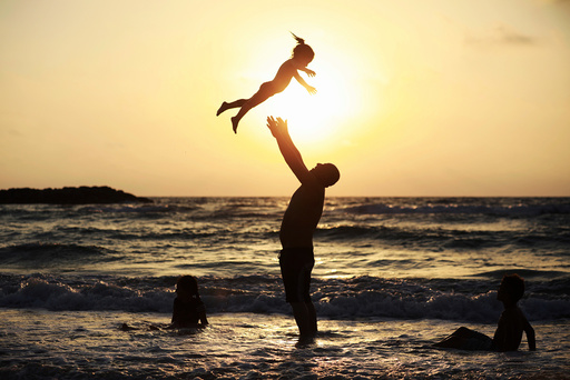 A Muslim man plays with his daughter along the shore of the Mediterranean Sea during the Muslim holiday of Eid al-Fitr, in Ashkelon