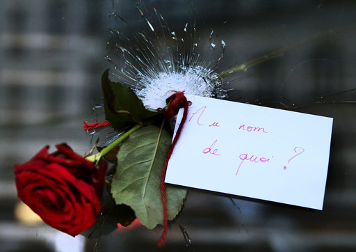 A rose placed in a bullet hole in a restaurant window the day after a series of deadly attacks in Paris