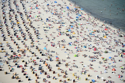 People sitting in beach chairs enjoy the hot sunny weather at the Baltic Sea resort Travemuende