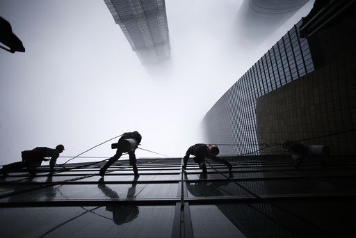 Workers clean the exterior of Shanghai's skyscraper Shanghai World Financial Center next to Shanghai Tower and Jin Mao Tower in Shanghai's financial district of Pudong