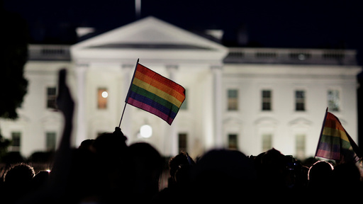 A rainbow flag is held up during a vigil after the worst mass shooting in U.S. history at a gay nightclub in Orlando, Florida, in front of the White House in Washington